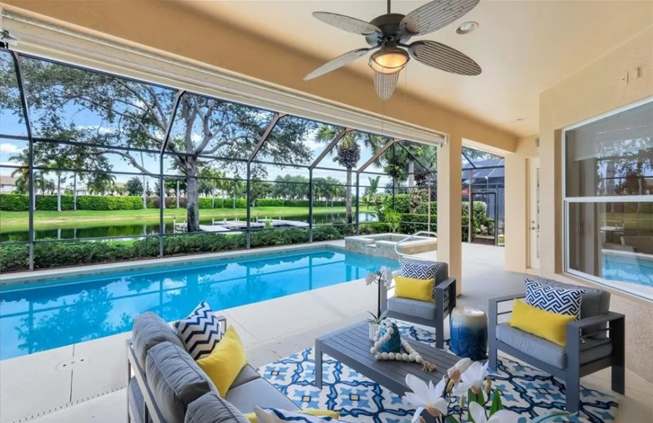 Luxury poolside lanai staged with modern furnishings and pool view by Naples Home Staging”